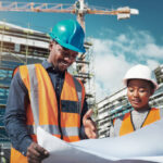 Shot of a young man and woman going over building plans at a construction site